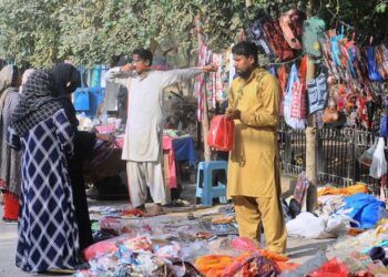 MULTAN:  Women customers selecting hand bags from a roadside vendor